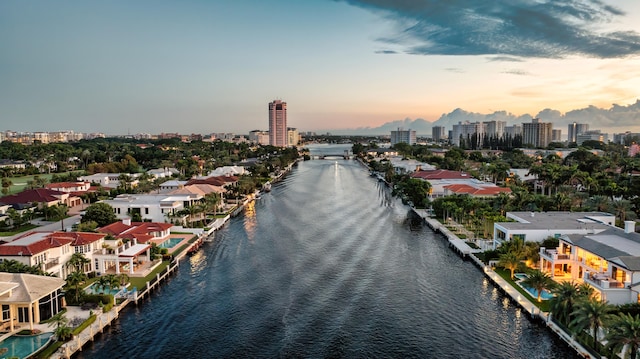 aerial view at dusk featuring a water view