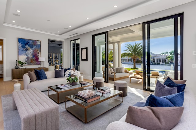 living room with crown molding, a water view, and wood-type flooring