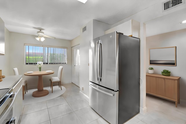 kitchen with ceiling fan, light tile patterned flooring, appliances with stainless steel finishes, and white cabinetry