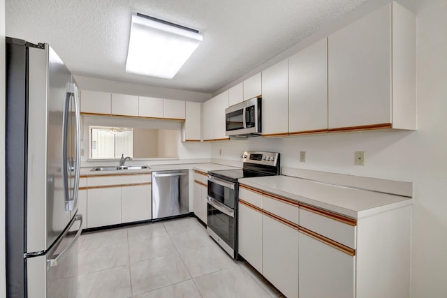 kitchen featuring appliances with stainless steel finishes, sink, and white cabinetry