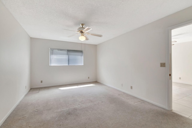 carpeted empty room featuring ceiling fan and a textured ceiling