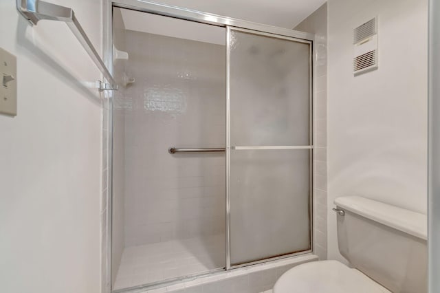 bathroom featuring walk in shower and toilet