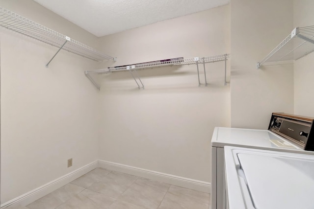 laundry area with a textured ceiling and washing machine and dryer