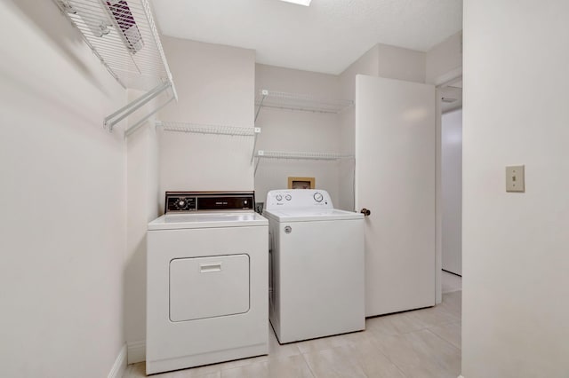 laundry room with light tile patterned floors and washing machine and dryer