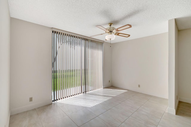 spare room with a textured ceiling, light tile patterned floors, and ceiling fan