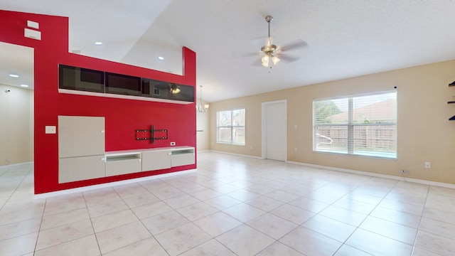 interior space featuring ceiling fan, light tile patterned floors, a healthy amount of sunlight, and lofted ceiling