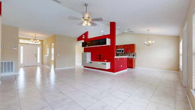 unfurnished living room featuring ceiling fan with notable chandelier, light tile patterned floors, and vaulted ceiling