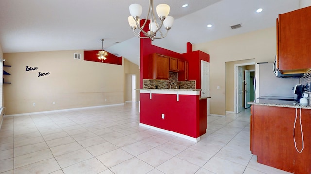 kitchen with a kitchen bar, light stone countertops, decorative light fixtures, an inviting chandelier, and range