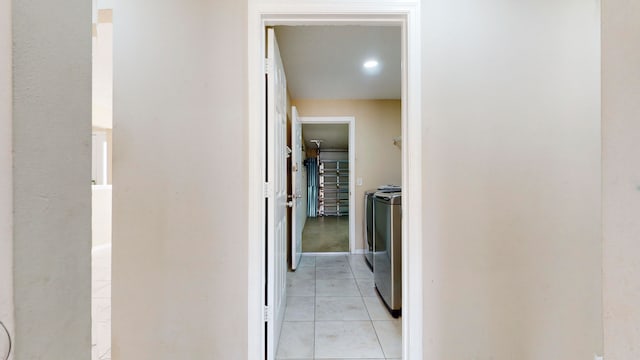 hall with washing machine and dryer and light tile patterned floors