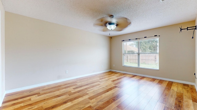 unfurnished room with ceiling fan, light hardwood / wood-style floors, and a textured ceiling