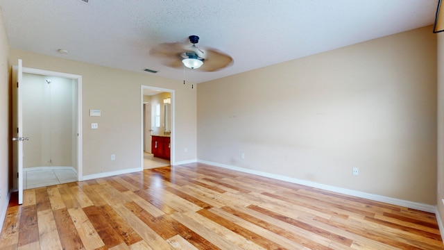 unfurnished bedroom with ensuite bath, ceiling fan, light hardwood / wood-style flooring, and a textured ceiling