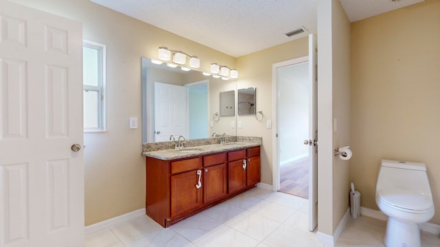 bathroom with tile patterned floors, vanity, toilet, and a textured ceiling