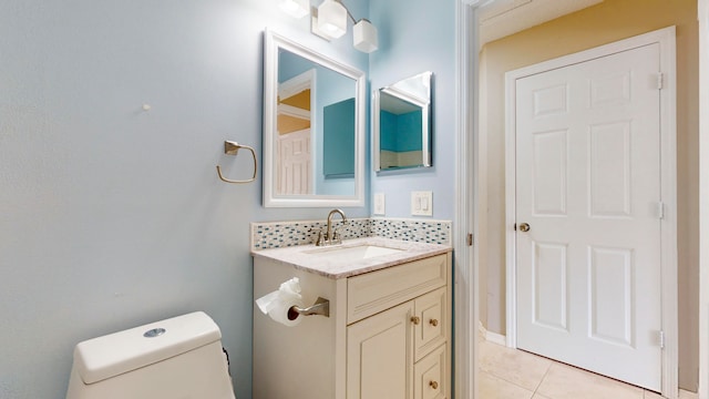 bathroom with tile patterned flooring, vanity, toilet, and backsplash