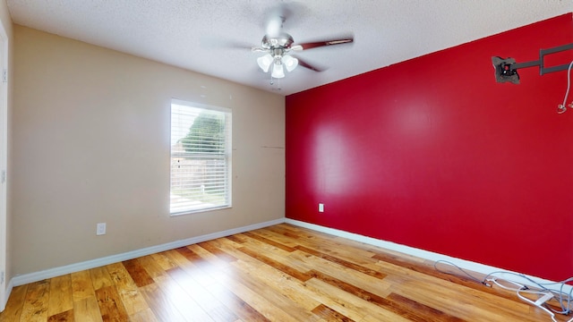 empty room with a textured ceiling, hardwood / wood-style flooring, and ceiling fan