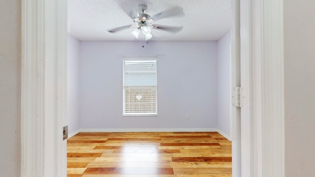 unfurnished room featuring ceiling fan, light hardwood / wood-style floors, and a textured ceiling