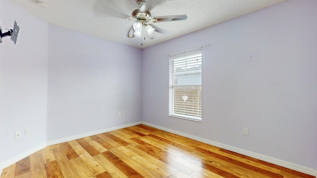 spare room with a textured ceiling, hardwood / wood-style flooring, and ceiling fan