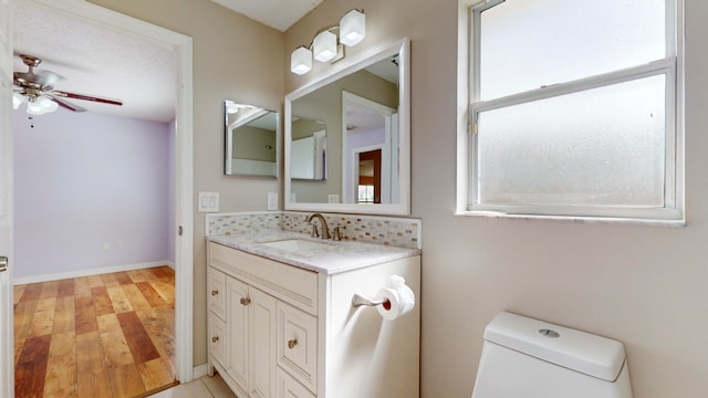 bathroom featuring vanity, ceiling fan, toilet, a textured ceiling, and wood-type flooring