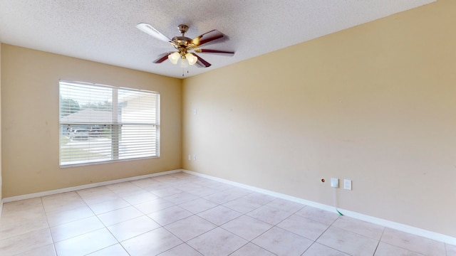 tiled empty room featuring ceiling fan and a textured ceiling