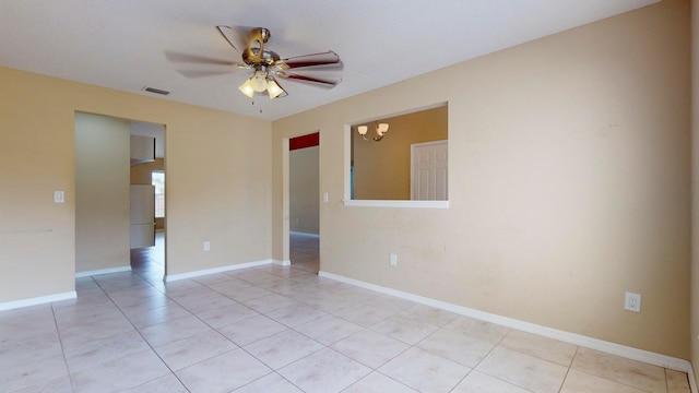 unfurnished room featuring light tile patterned flooring and ceiling fan with notable chandelier