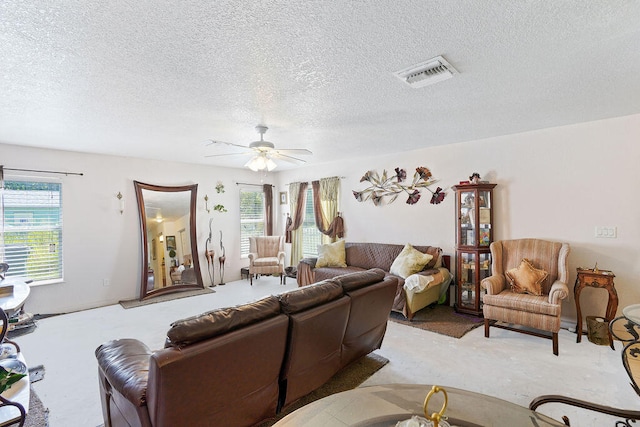 carpeted living room featuring plenty of natural light, ceiling fan, and a textured ceiling