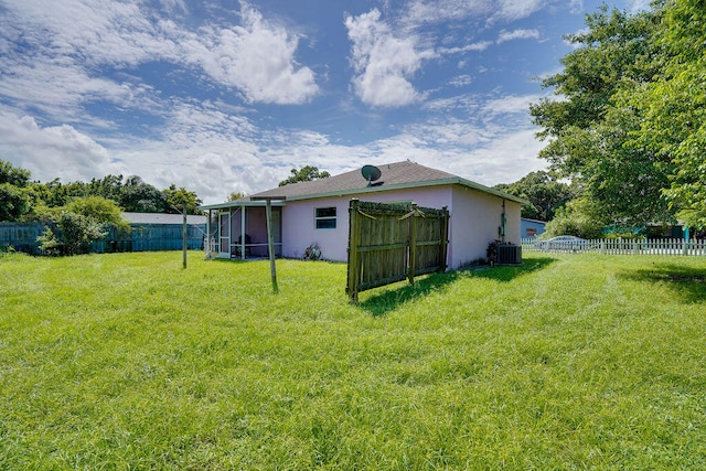 view of yard featuring a sunroom and central air condition unit