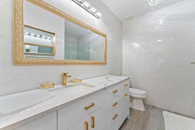 bathroom with vanity, tile walls, hardwood / wood-style floors, and toilet