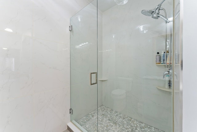 bathroom with a shower with door and toilet