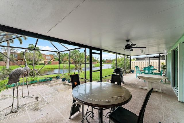 view of patio featuring grilling area, a water view, a lanai, and ceiling fan