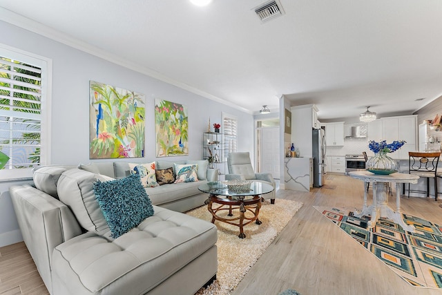 living room with light hardwood / wood-style flooring and crown molding