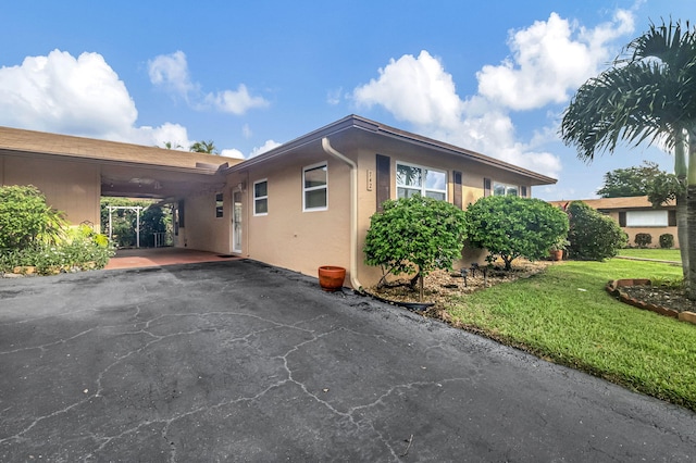 view of front of property featuring a front yard and a carport