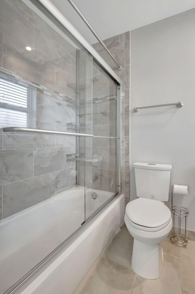 bathroom featuring enclosed tub / shower combo and toilet