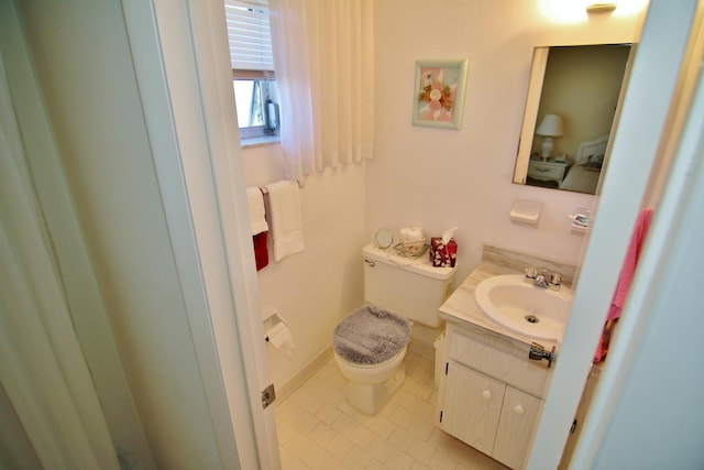 bathroom with tile patterned flooring, vanity, and toilet