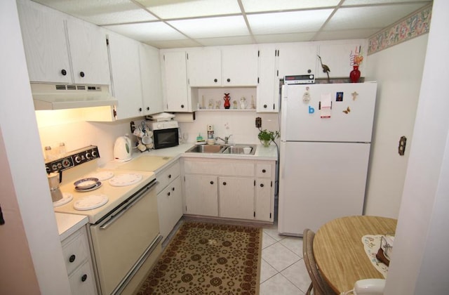 kitchen featuring a drop ceiling, white appliances, white cabinetry, and sink