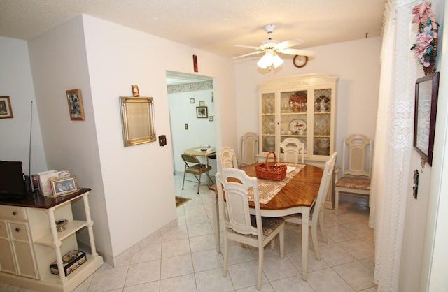 tiled dining room featuring ceiling fan and a textured ceiling