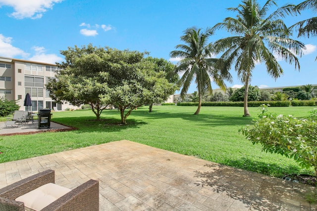 surrounding community with a yard and a patio area