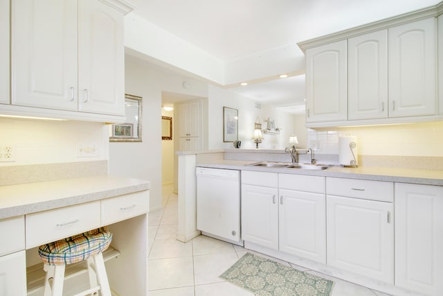 kitchen with sink, white cabinetry, backsplash, light tile patterned floors, and white dishwasher