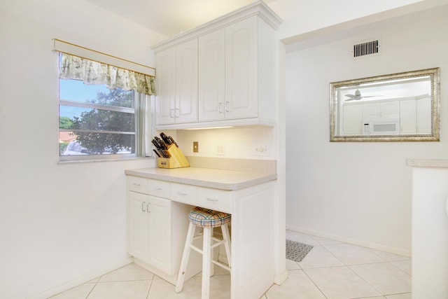 kitchen with light tile patterned floors and white cabinets