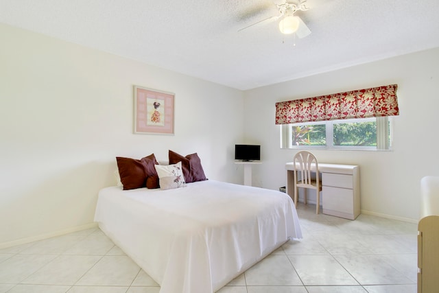 bedroom featuring a textured ceiling, light tile patterned floors, and ceiling fan