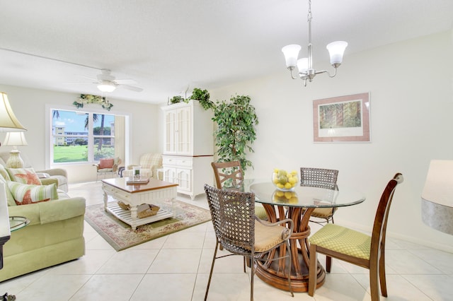 tiled dining room with ceiling fan with notable chandelier