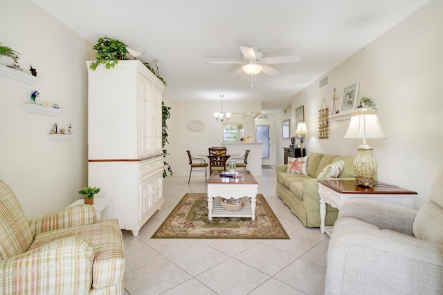 tiled living room featuring ceiling fan with notable chandelier