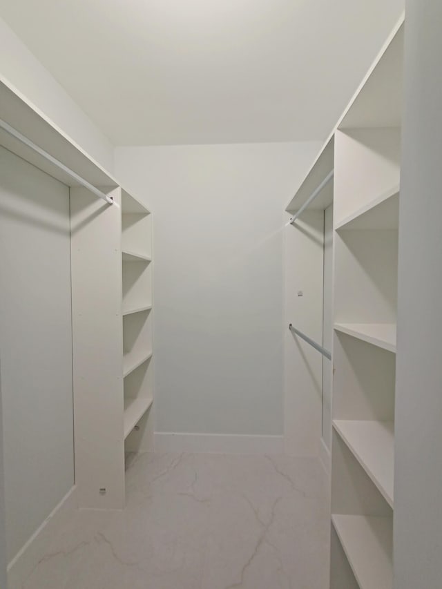 walk in closet with marble finish floor