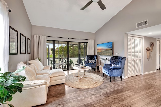 living room with ceiling fan, hardwood / wood-style flooring, and high vaulted ceiling