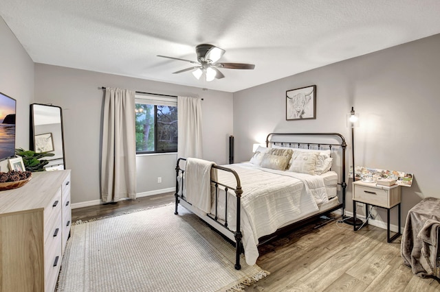 bedroom featuring a textured ceiling, light hardwood / wood-style floors, and ceiling fan