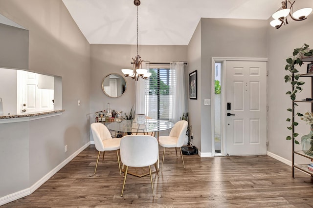 dining room with a notable chandelier, high vaulted ceiling, and dark hardwood / wood-style flooring