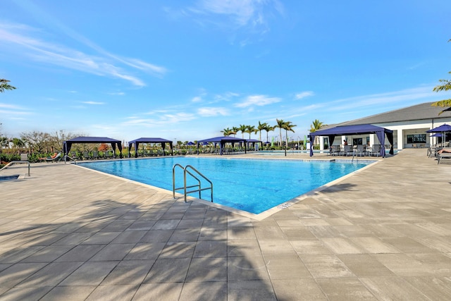 view of swimming pool featuring a patio and a gazebo