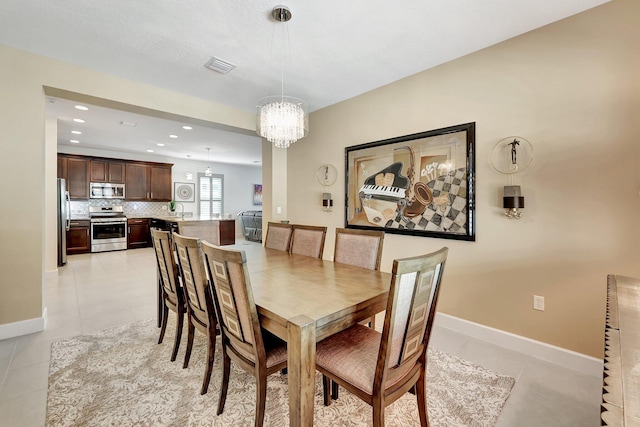 tiled dining room featuring sink and an inviting chandelier