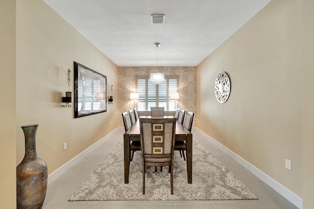 dining space with light tile patterned flooring, a textured ceiling, and a chandelier