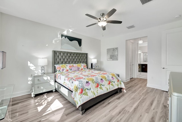 bedroom featuring light hardwood / wood-style floors, ensuite bathroom, and ceiling fan