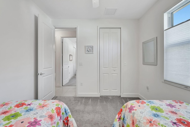 bedroom with a closet, ceiling fan, and light colored carpet