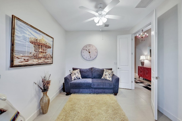 tiled living room with ceiling fan with notable chandelier